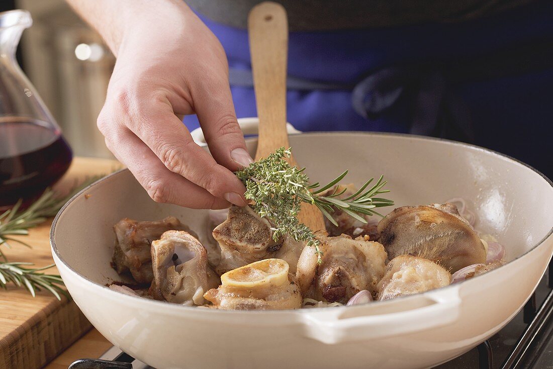 Herbs being added to roasted veal