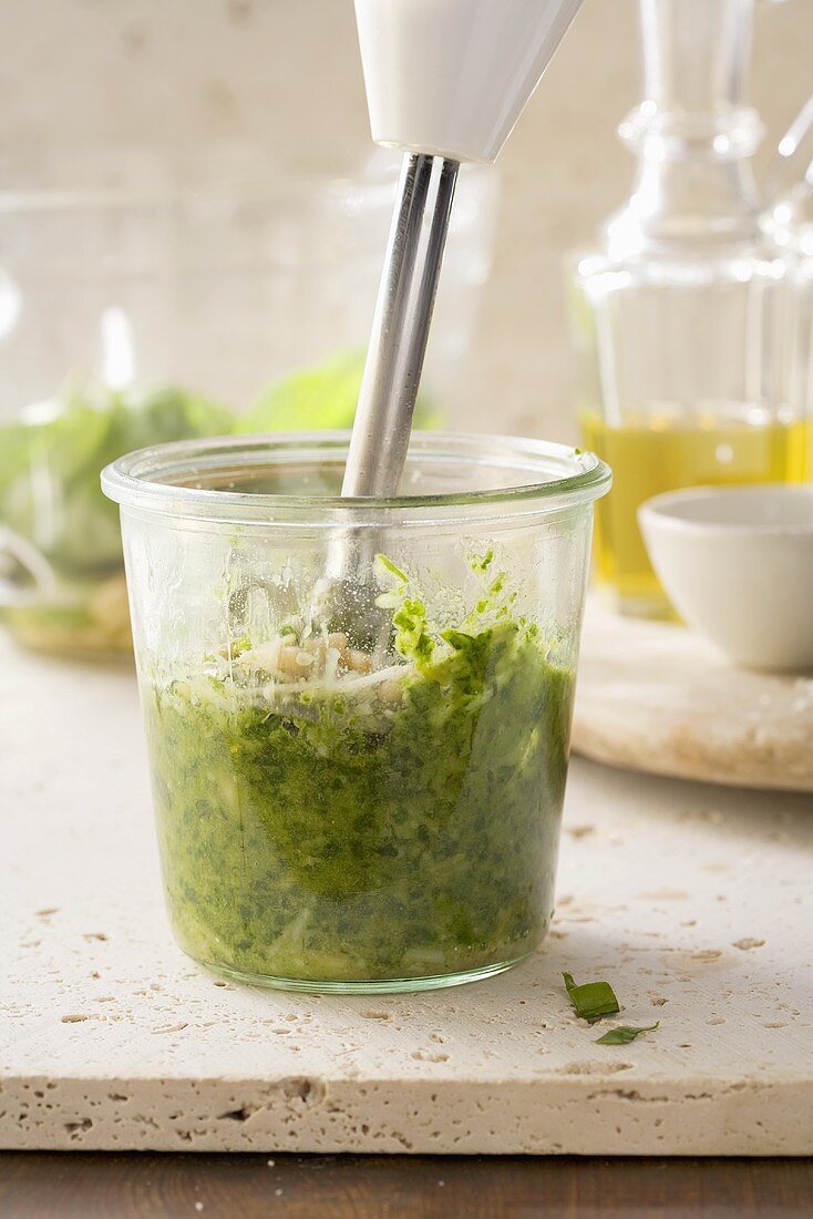 Ingredients for pesto being puree with a hand mixer