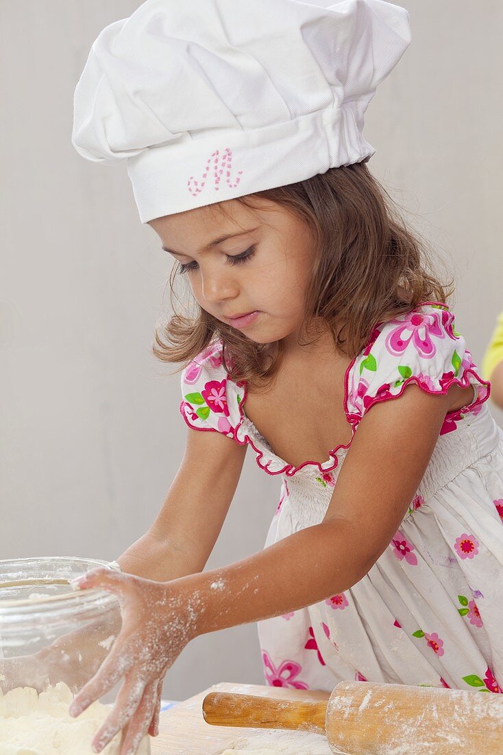 Small girl making dough