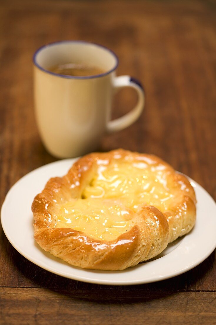 A vanilla pastry with a cup of coffee