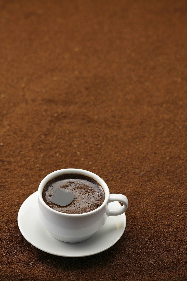 A cup of black coffee on coffee powder