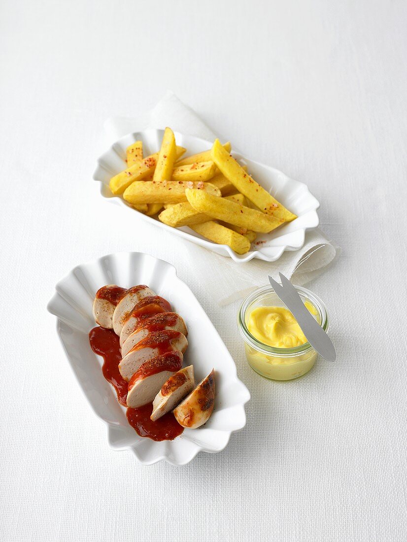 Currywurst mit Ketchup, dazu Pommes frites und Mayonnaise