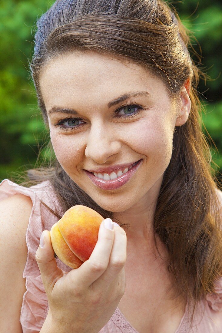 Young woman with a yellow peach