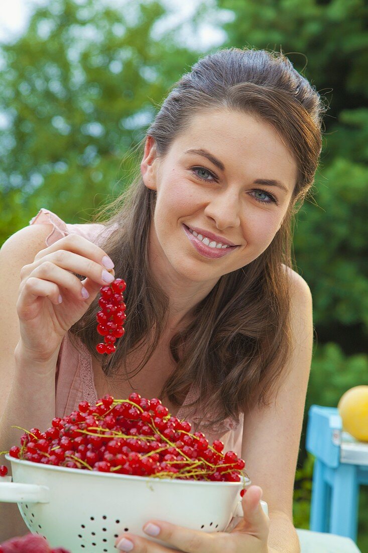 Young woman with freshly picked red currants