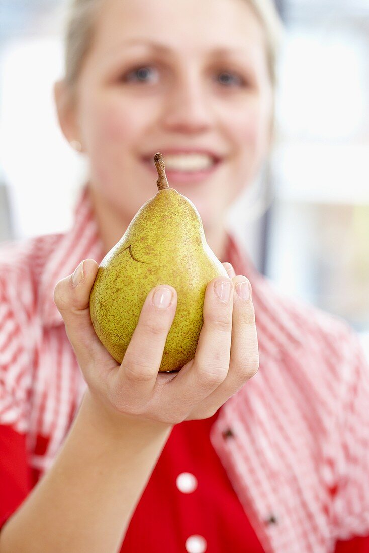A woman holding a pear