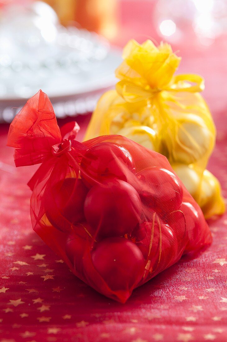 Rote und gelbe Säckchen mit Weihnachtskugeln