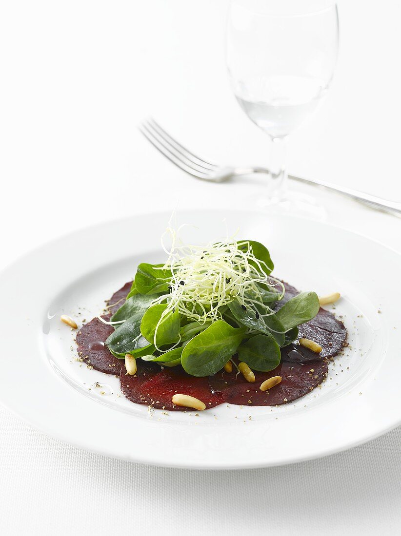 Red beet salad with pine nuts, spinach and basil