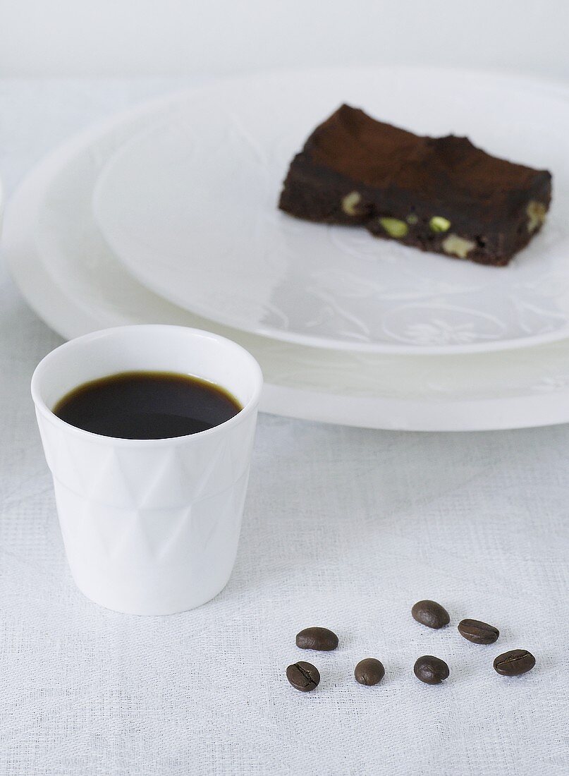 Kaffee, Kaffeebohnen und Brownie mit Pistazien