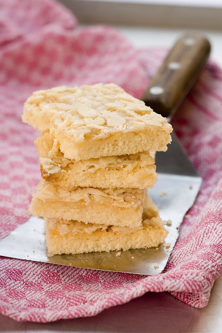 Several pieces of butter cake, stacked, on a cake server