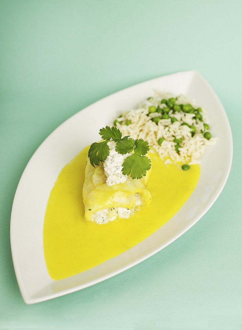 Fish fillet with shrimp filling, saffron sauce and rice with peas