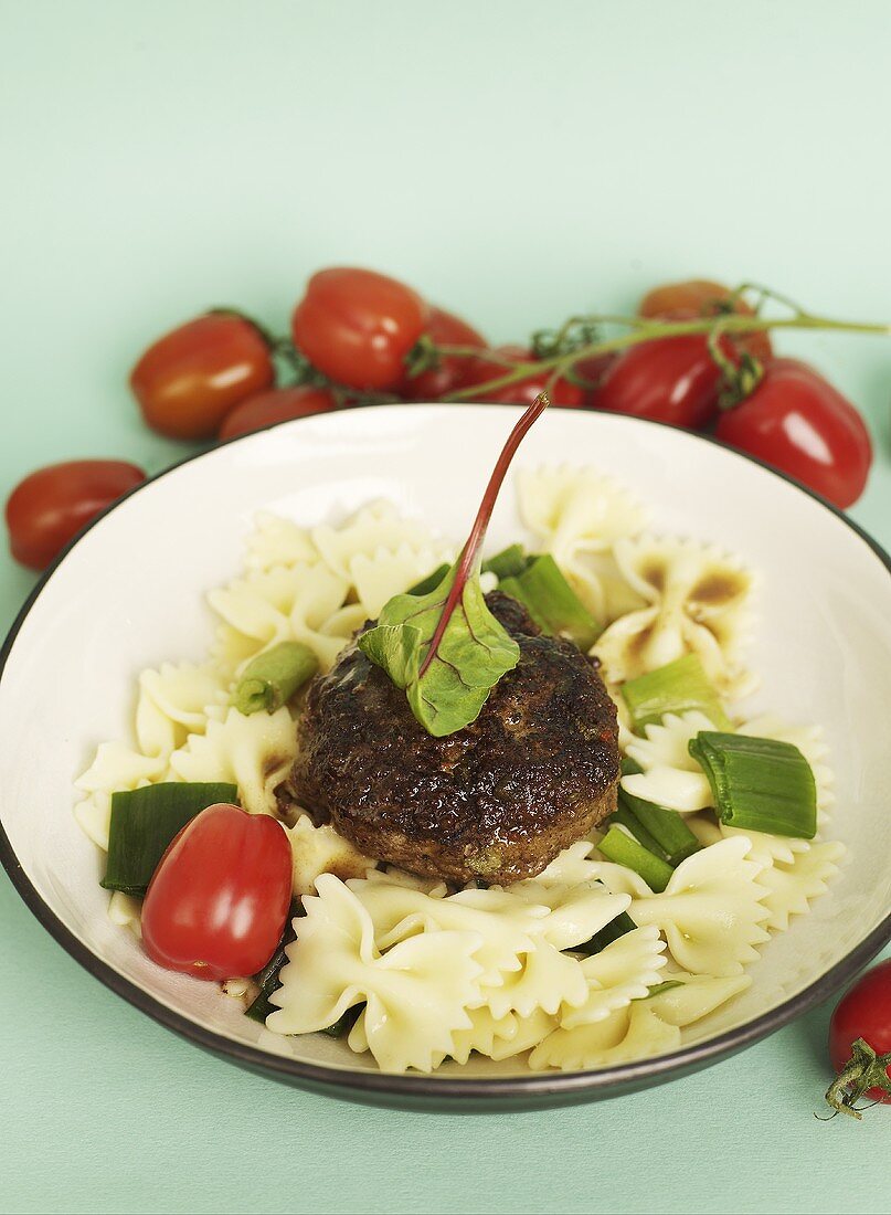 A meatball with capers, tomatoes and Farfalle