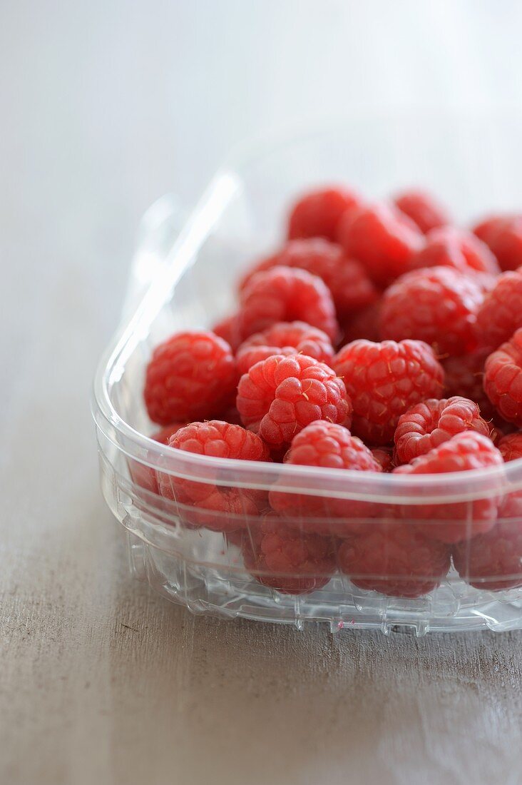 Raspberries in a plastic dish