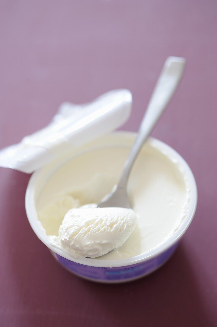 Mascarpone in an open container with spoon