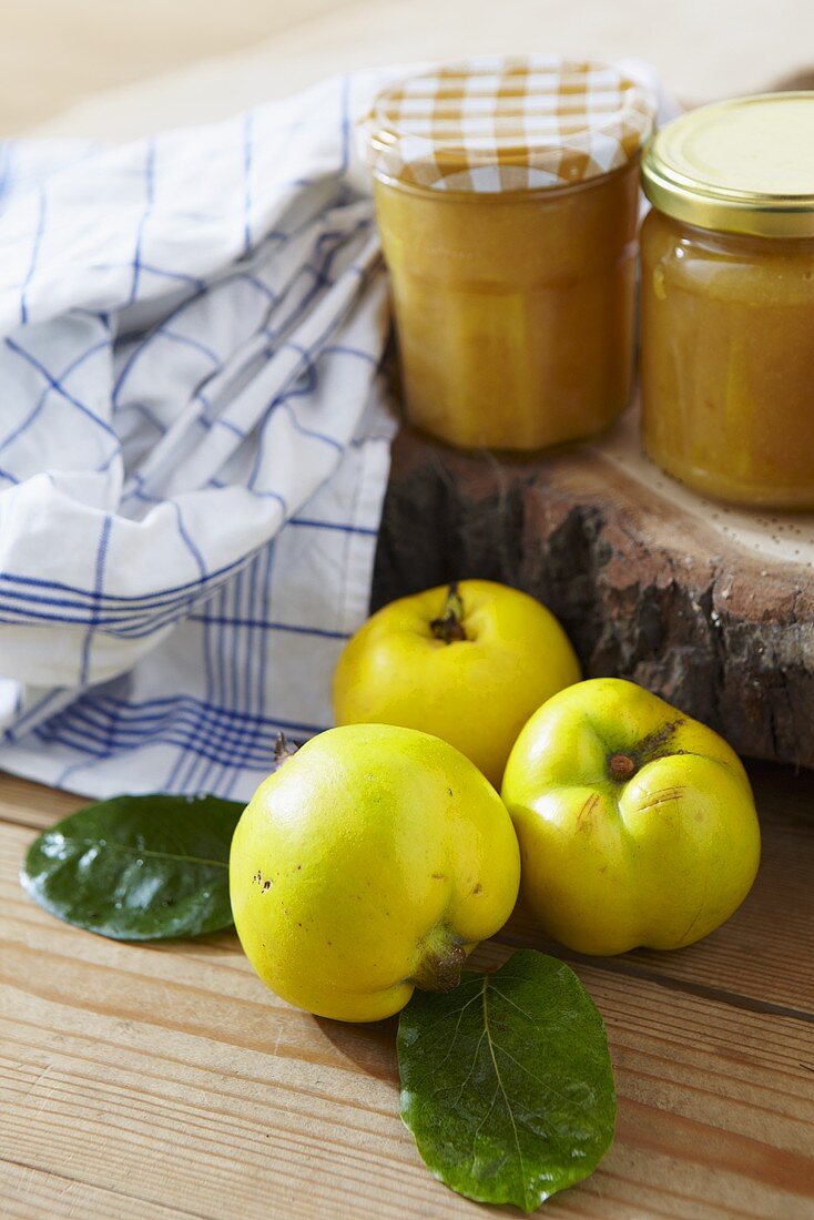 Two jars of quince jam and fresh quinces