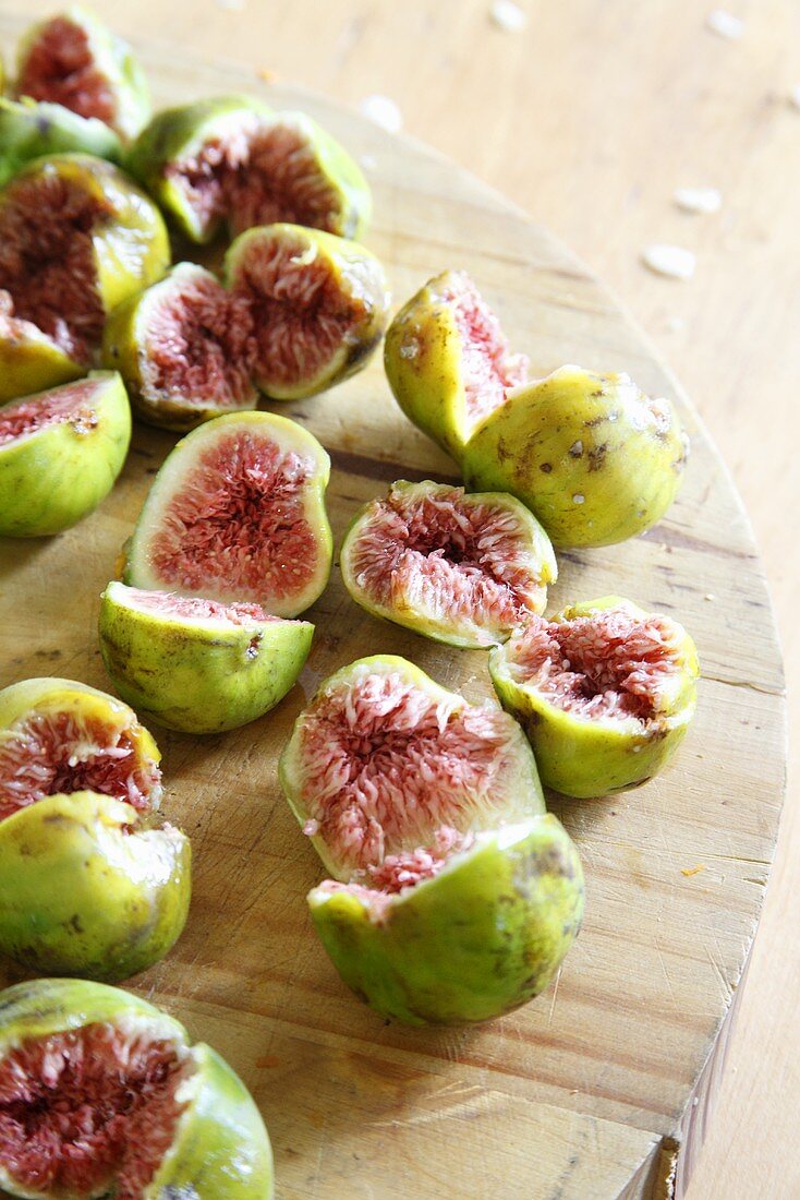 Fresh figs, halved, on a wooden board