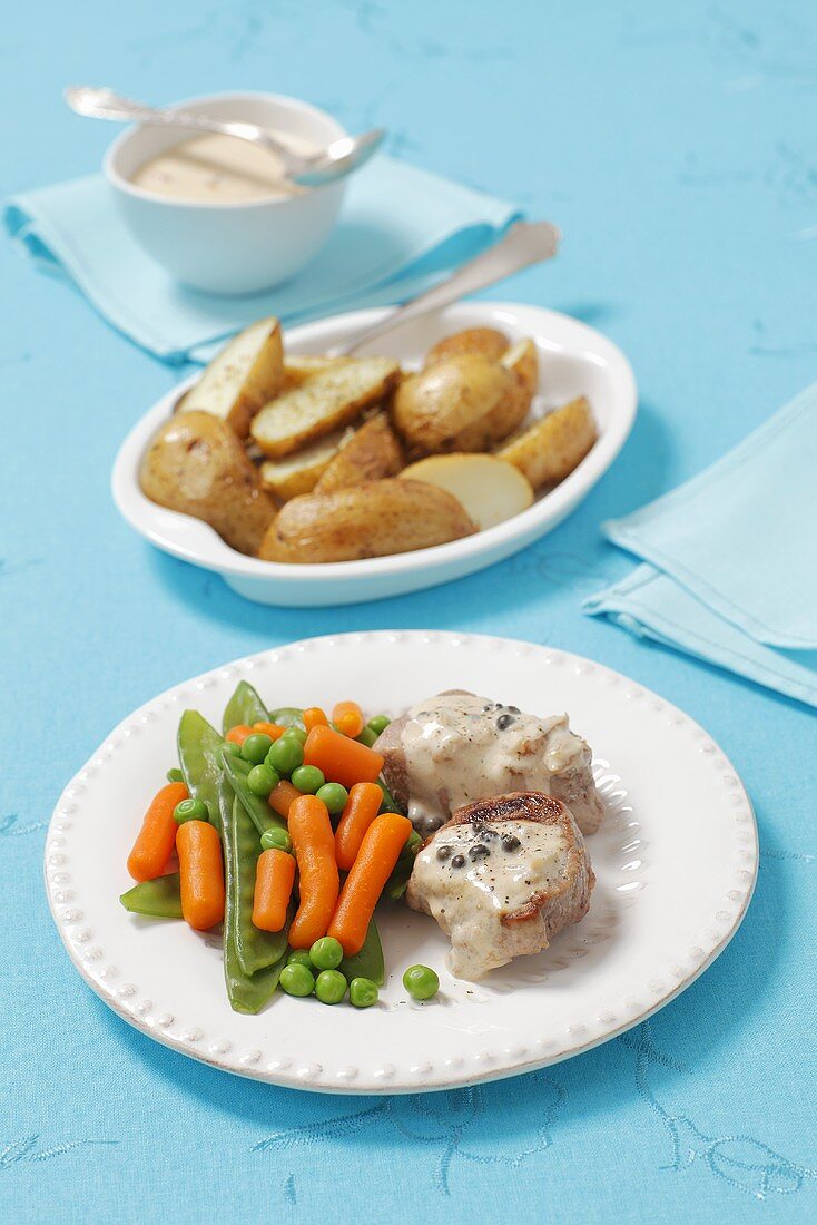 Pork medallions with caper sauce and vegetables on the side