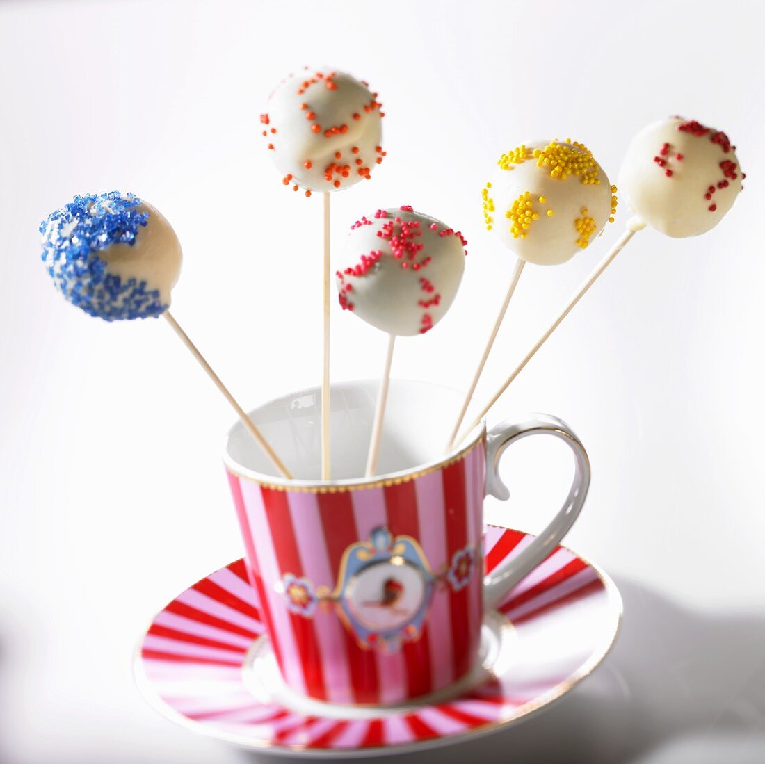 Cake Pops mit bunten Zuckerstreuseln in Tasse