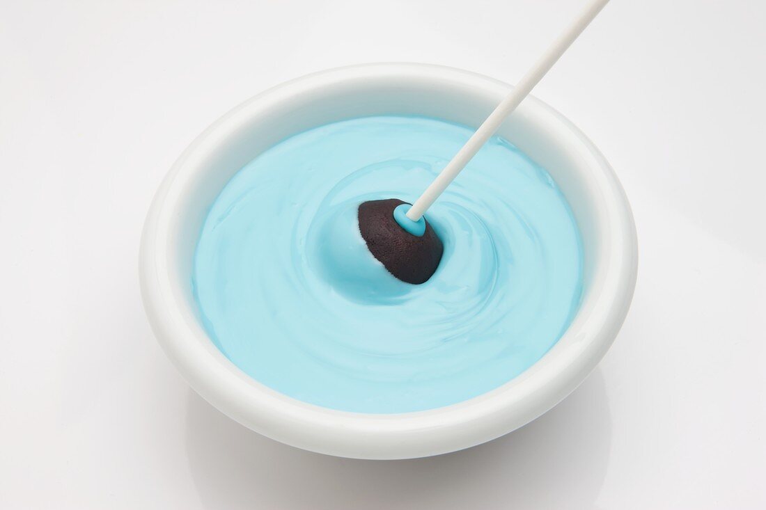 Cake Pop in blaue Glasurmasse tauchen