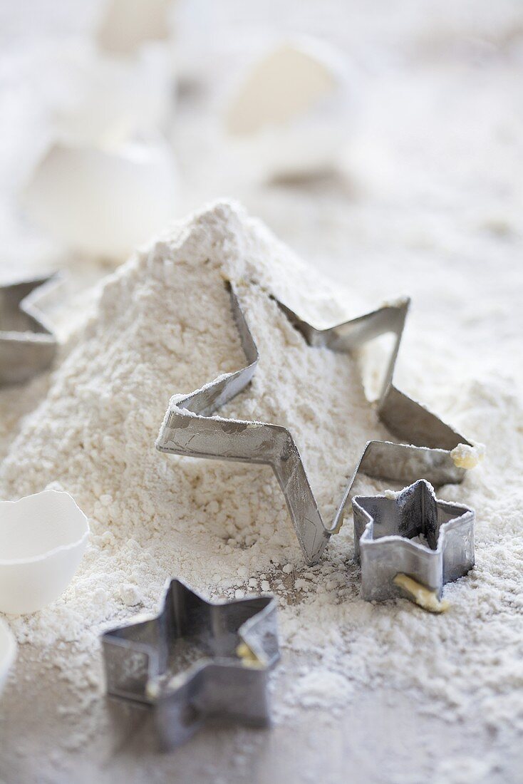 Star-shaped cutters on top of a pile of flour
