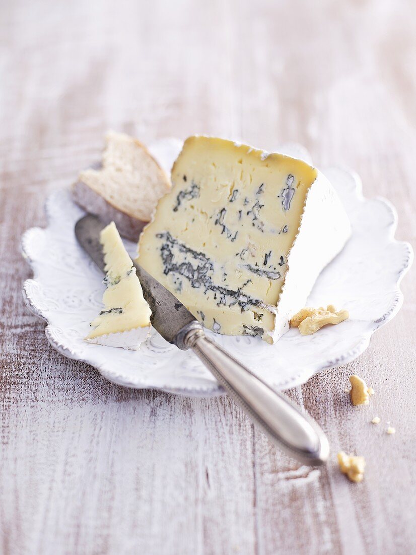 A slice of blue cheese on a plate with a knife