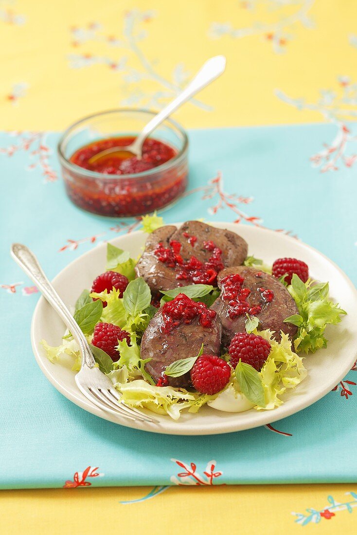 Turkey liver with raspberry sauce on a mixed leaf salad