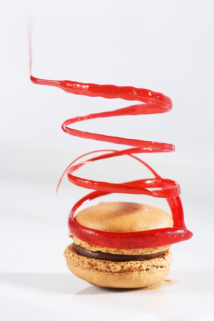 Schokoladen-Macaron mit roter Zuckerspirale