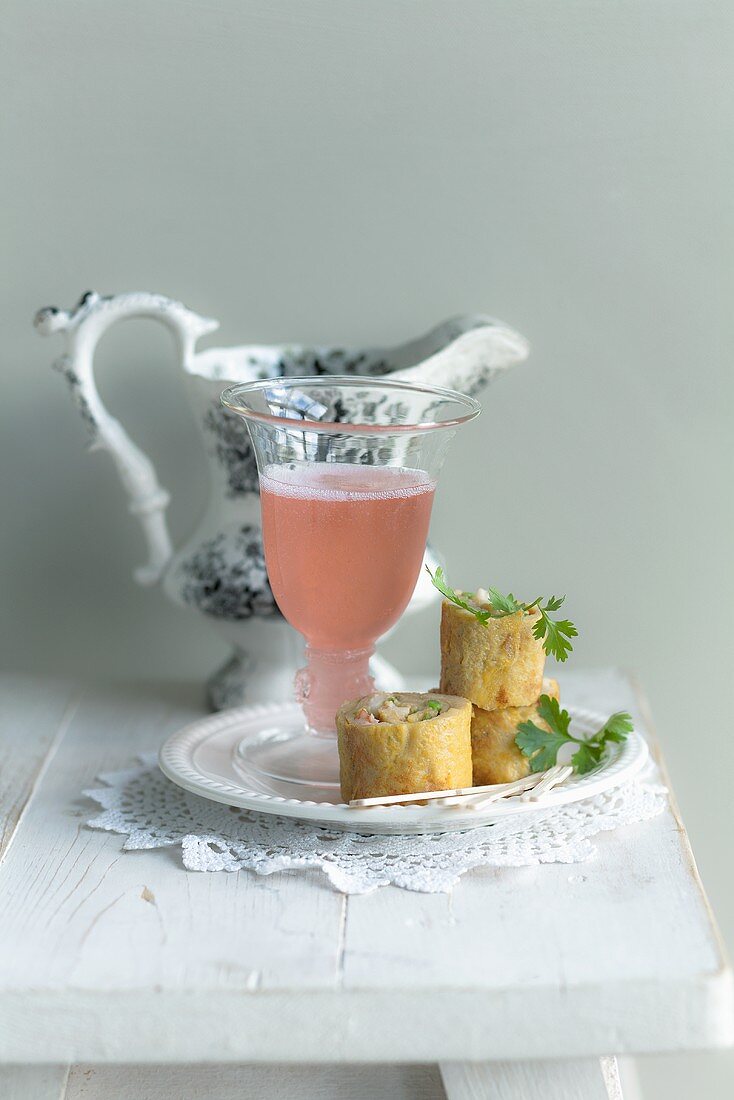 Prosecco with a rhubarb broth and omelette rolls with prawns