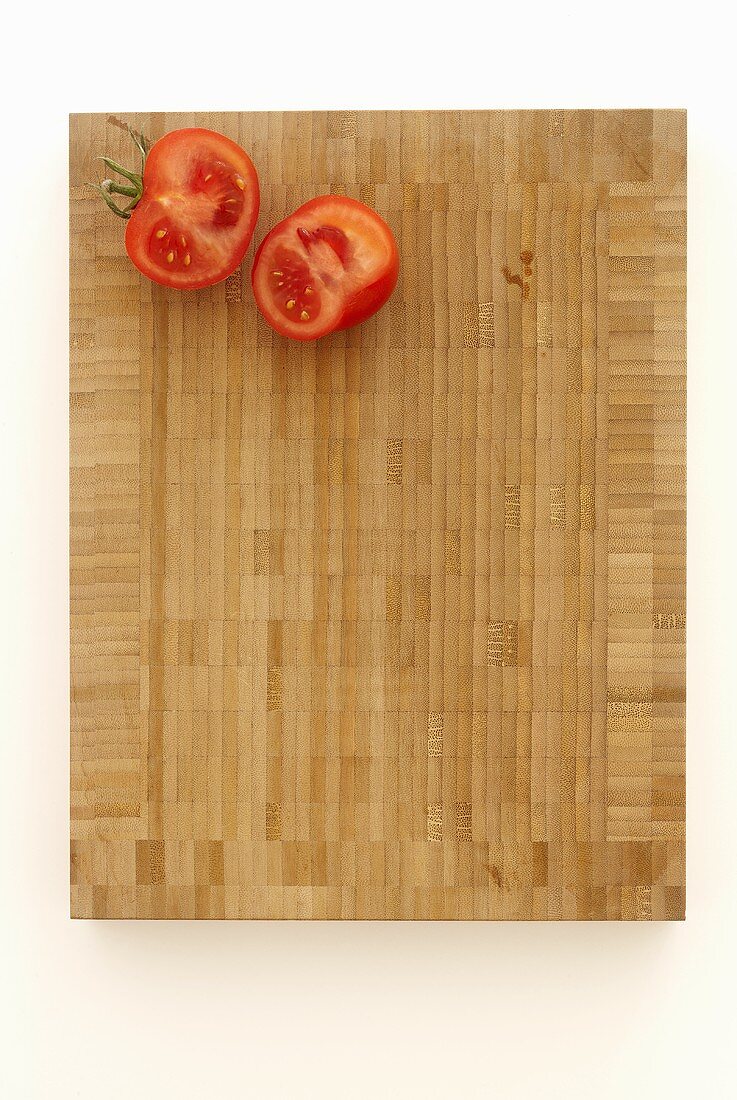Two tomato halves on a chopping board
