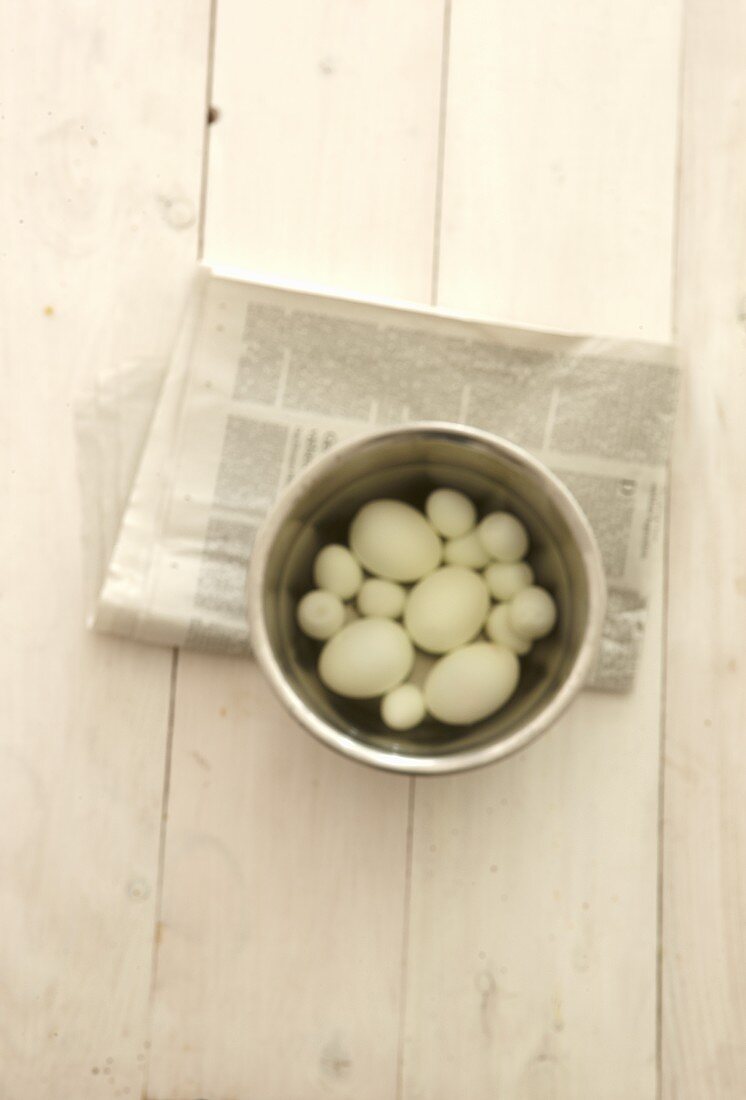 Eier im Kochtopf auf Zeitung