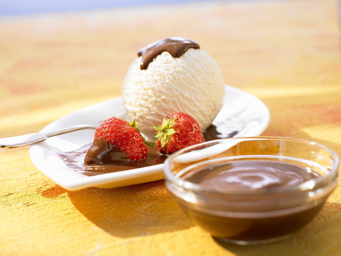 Vanilla ice cream with chocolate sauce and strawberries