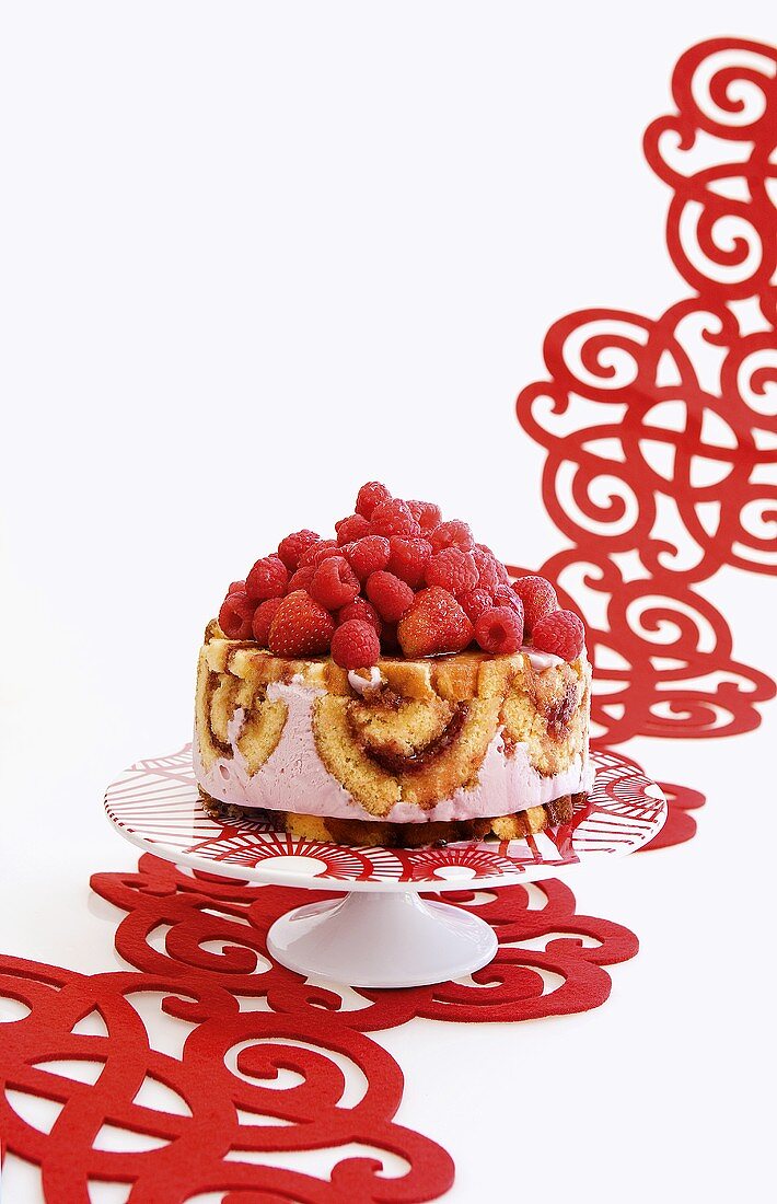 An ice cream cake with sponge rolls and fresh berries