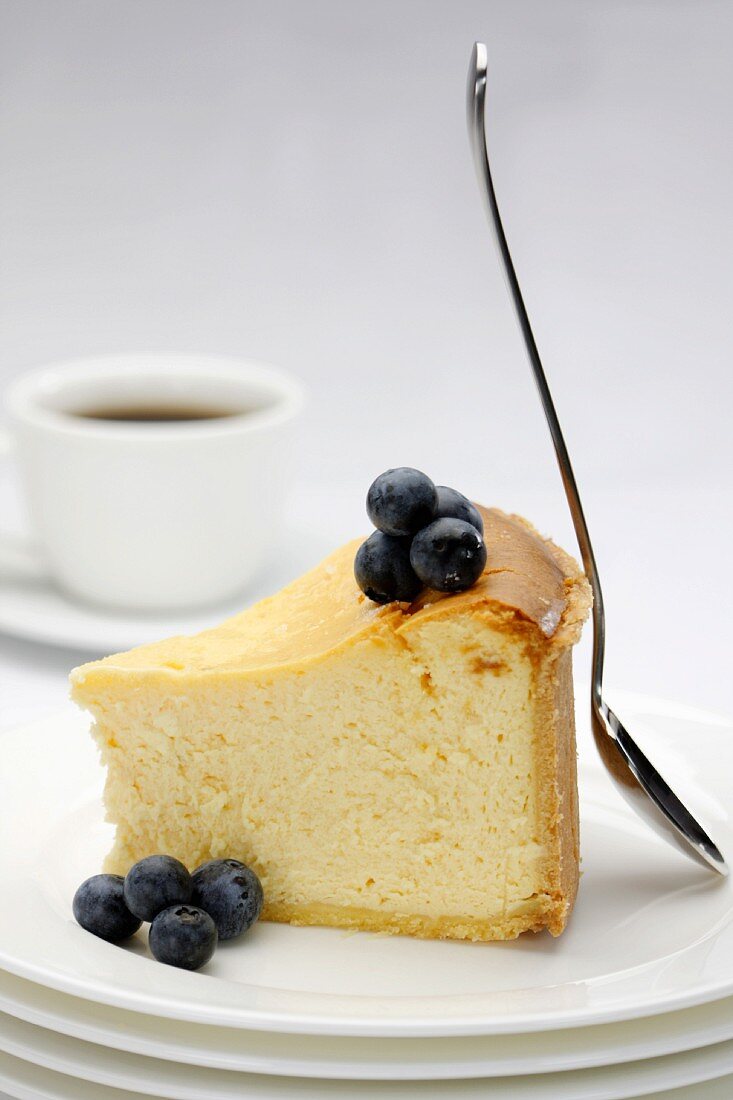 A slice of cheesecake with fresh blueberries