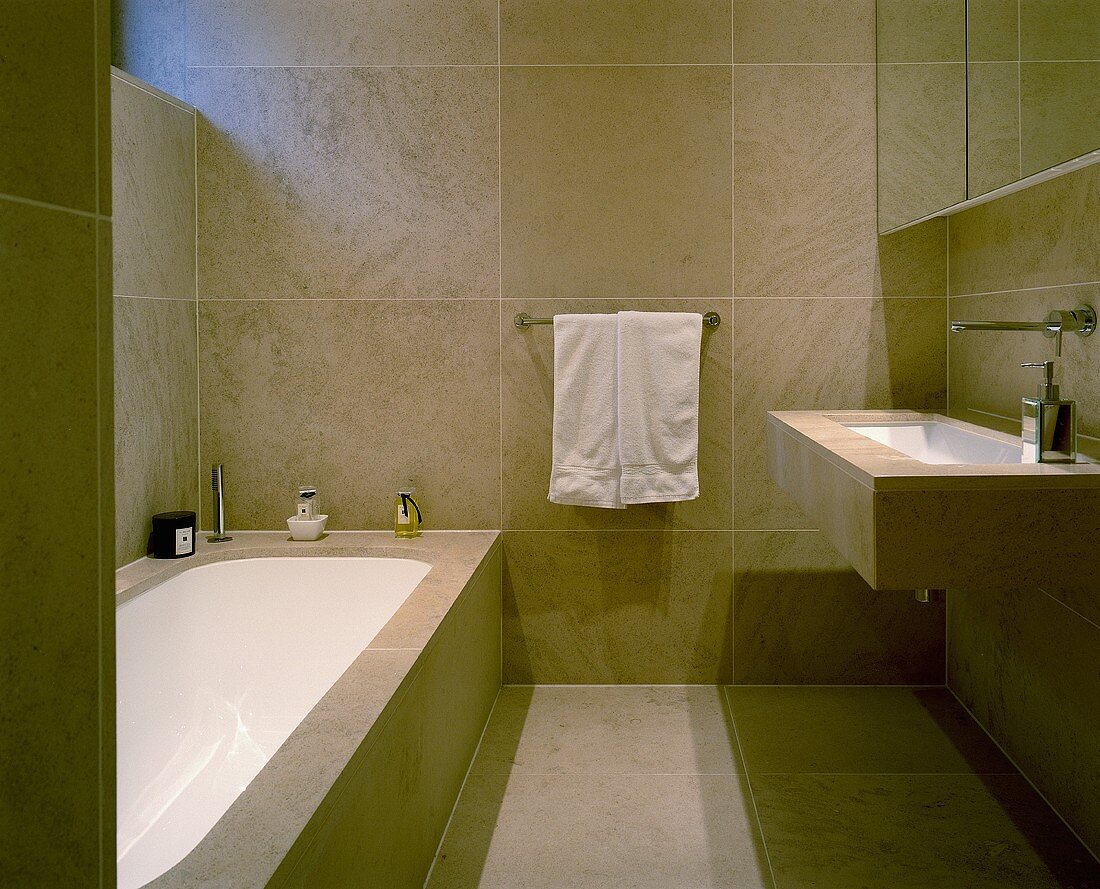 An elegant designer bathroom with light brown floor and wall tiles