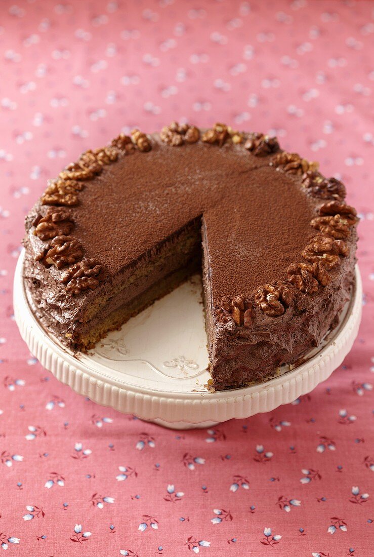 Slice of German Chocolate Cake on a White Plate; Whole Cake