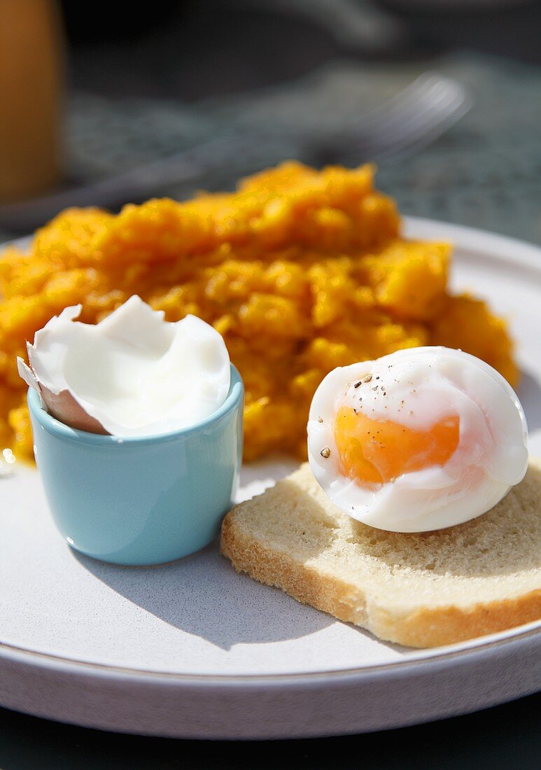 Wachsweiches Ei auf Toast vor Kürbispüree