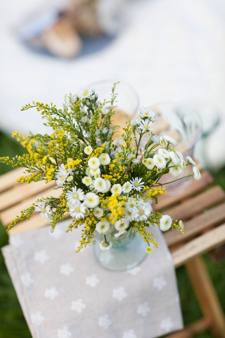 A bunch of meadow flowers on a stool