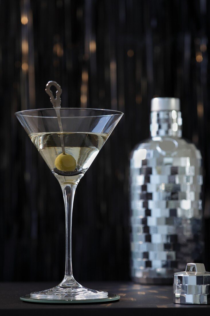 A Martini with an olive in a glass
