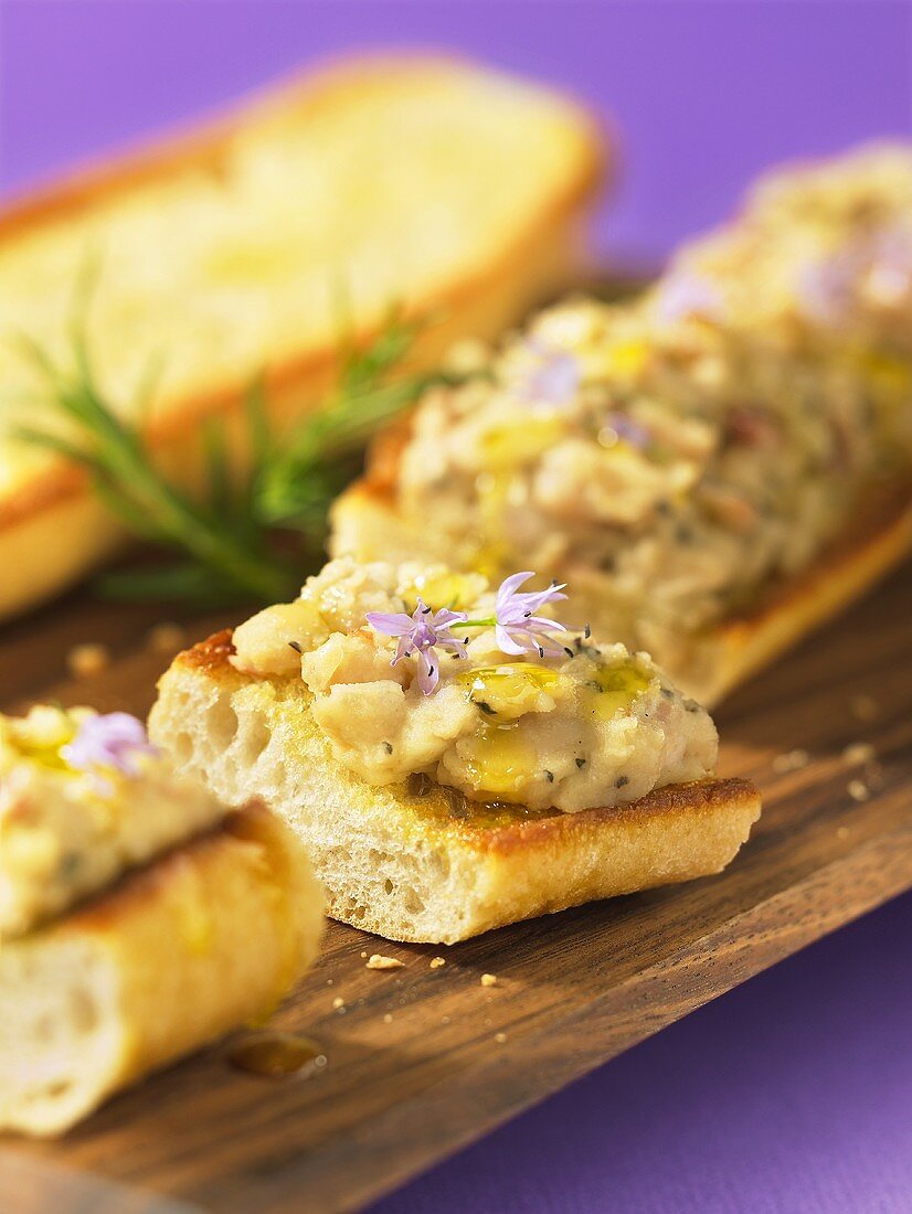 Bruschetta mit weißem Bohnenaufstrich auf Schneidebrett