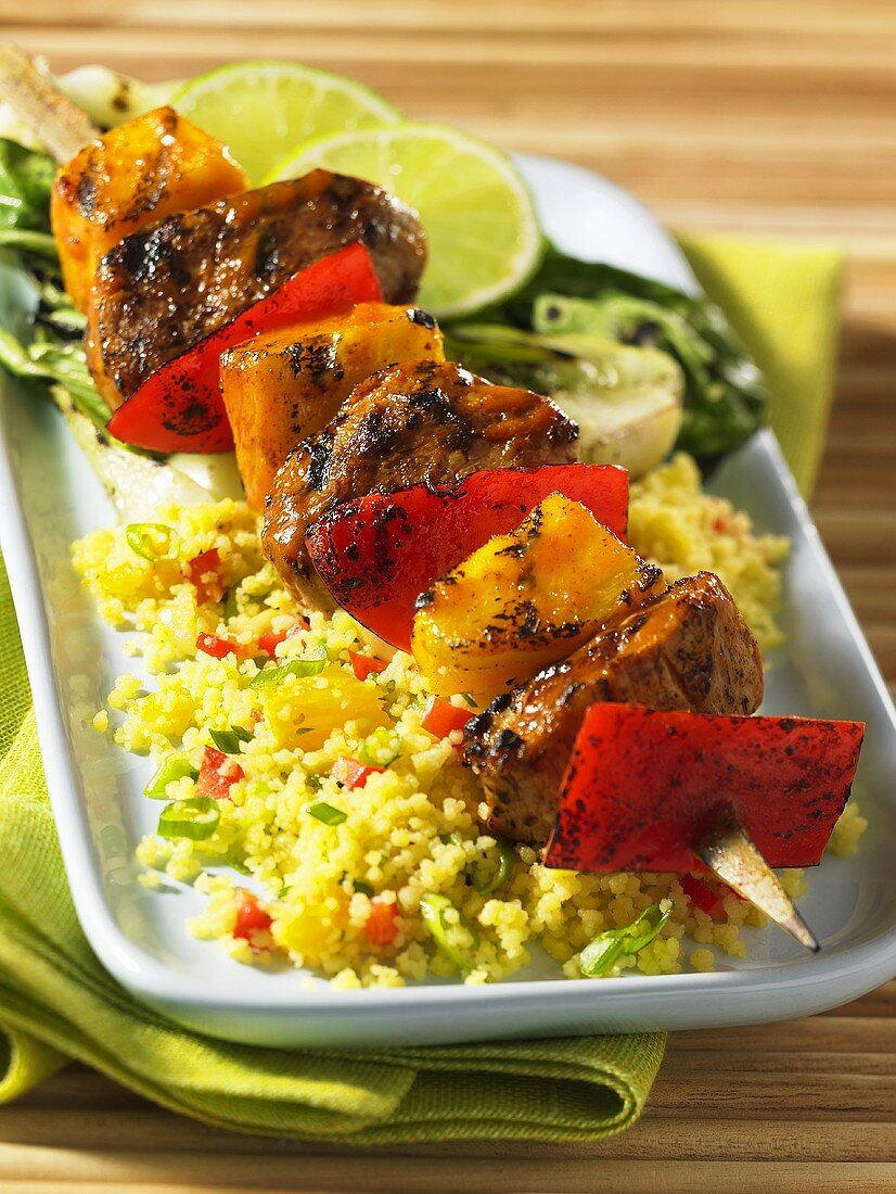 A grilled pork and mango kebab on a bed of couscous