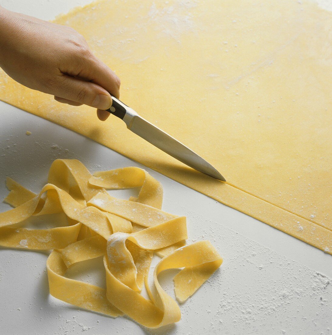 Cutting ribbon pasta from rolled-out pasta dough