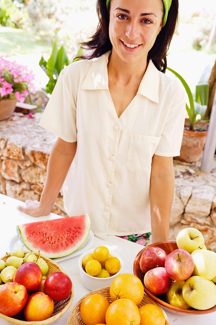 Young woman in front of a range of fruit