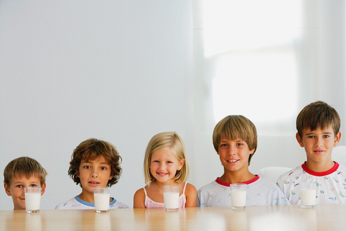 Fünf Kinder mit fünf Milchgläsern