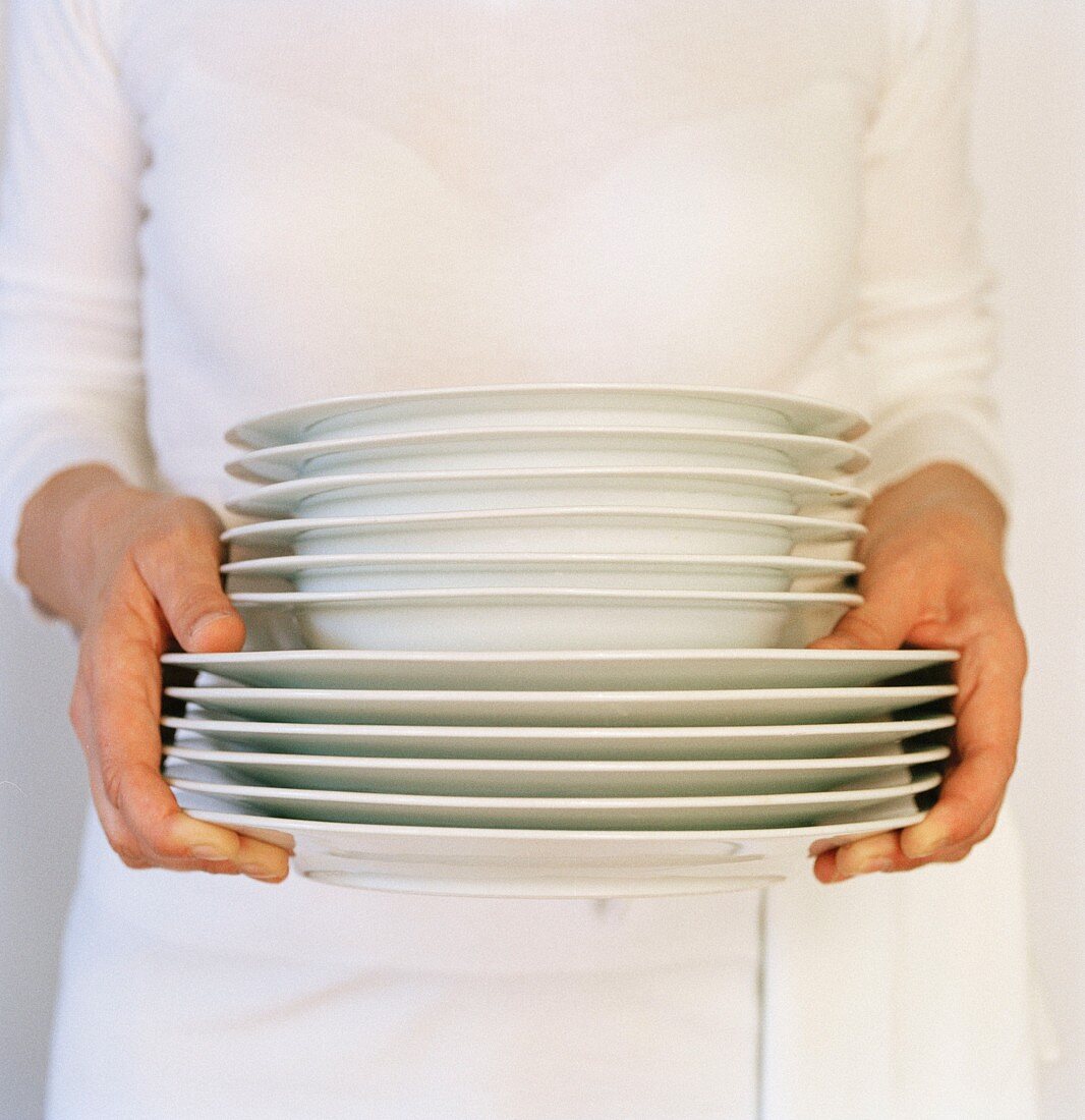 Waitress with stack of plates