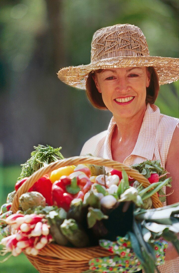 Frau mit Korb voller Gemüse