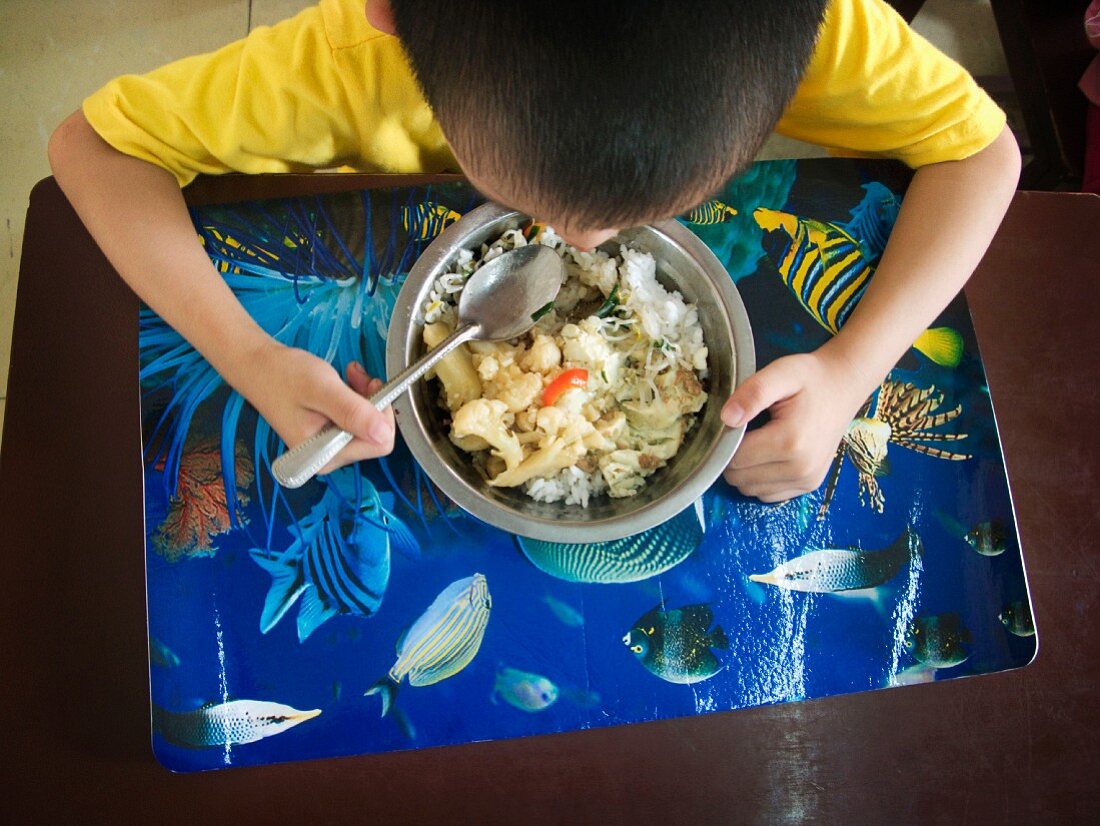 Chinesischer Junge isst in der Schule, Wuhan. Hubei, China