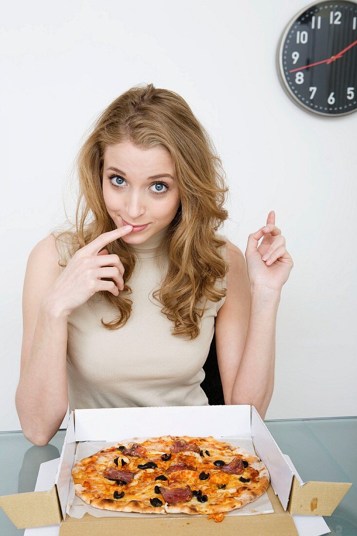 Junge Frau isst Pizza