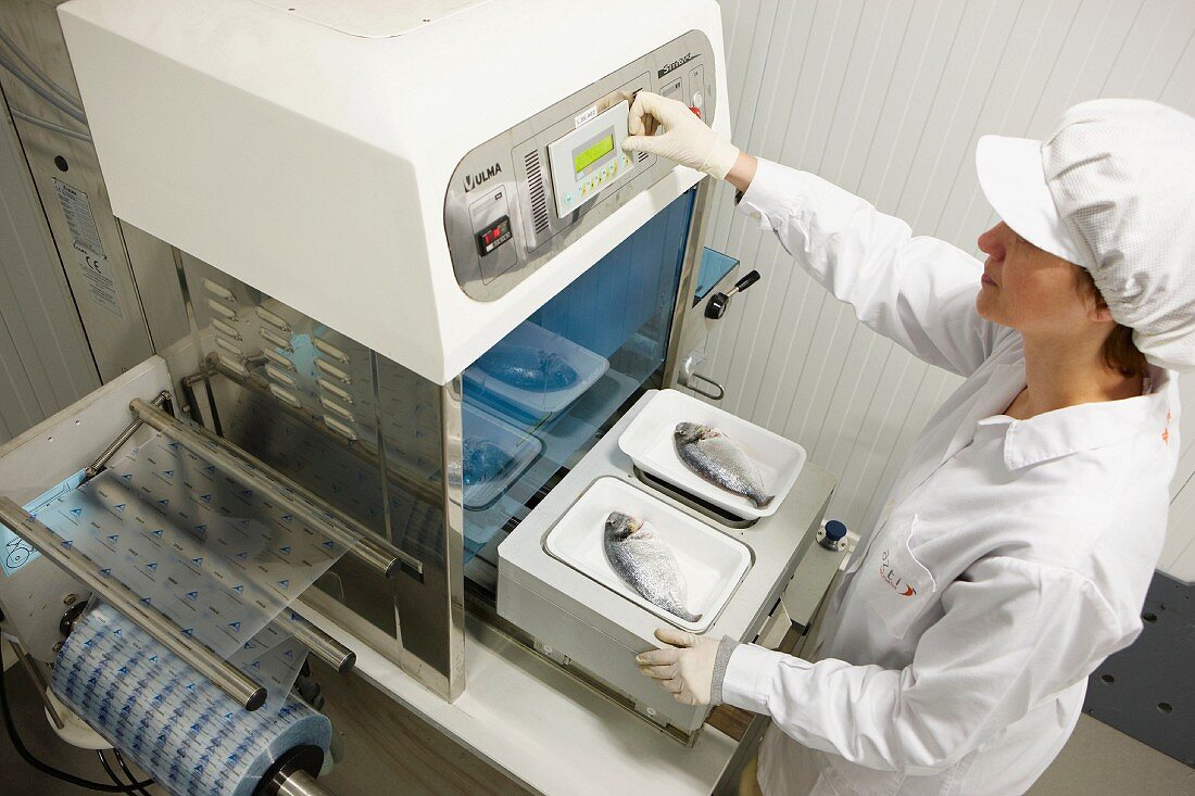 Lebensmitteltechnikerin testet Verpackungsmaschine