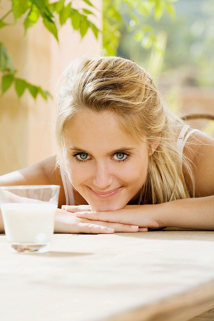 Junge, blonde Frau mit einem Glas Milch