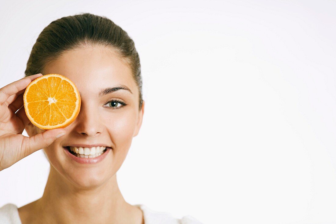 Junge Frau mit einer Orangenscheibe