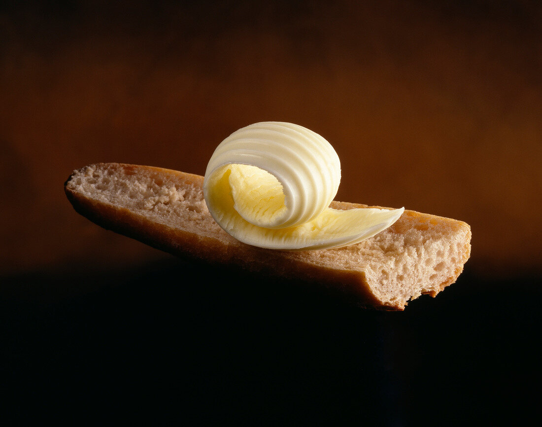 Butterlocke auf einem Stück Baguette